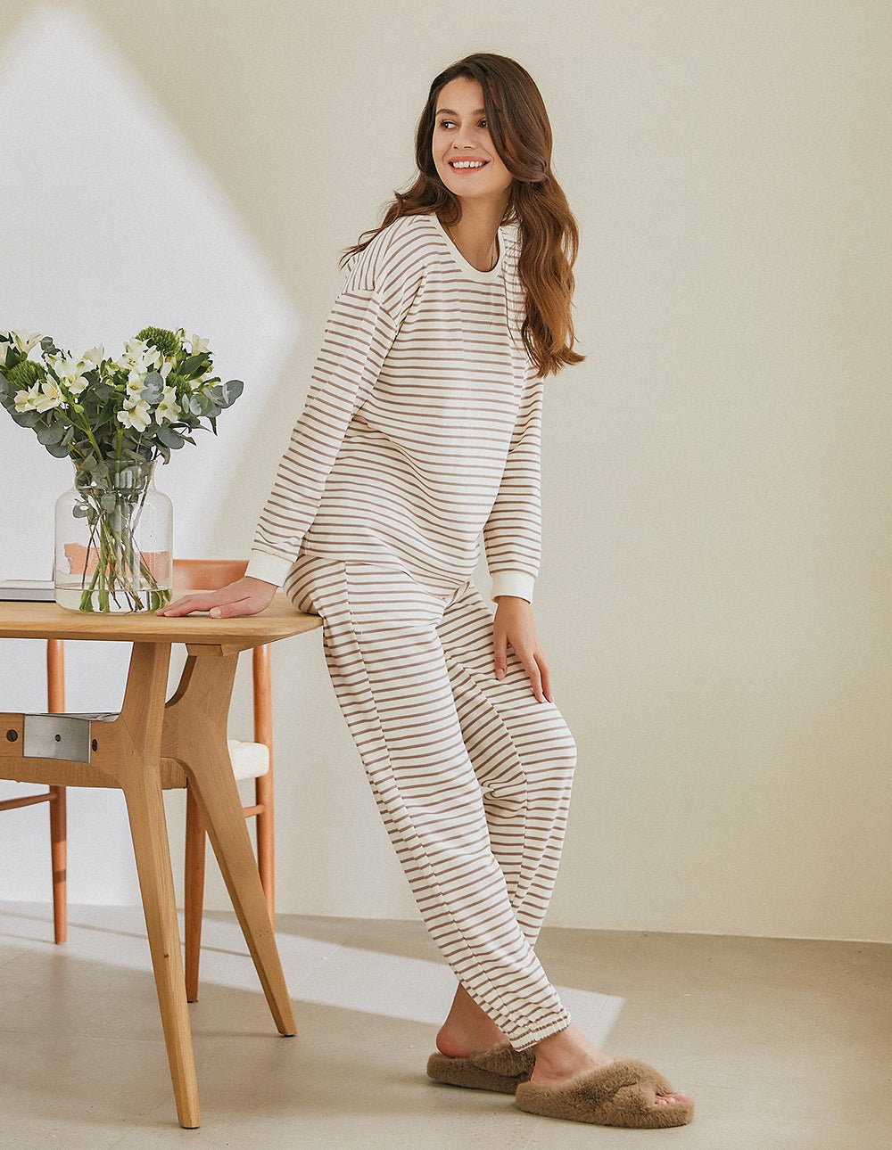 Striped cotton pajama set, long-sleeve top and pants, cream with dark stripes, walking pose