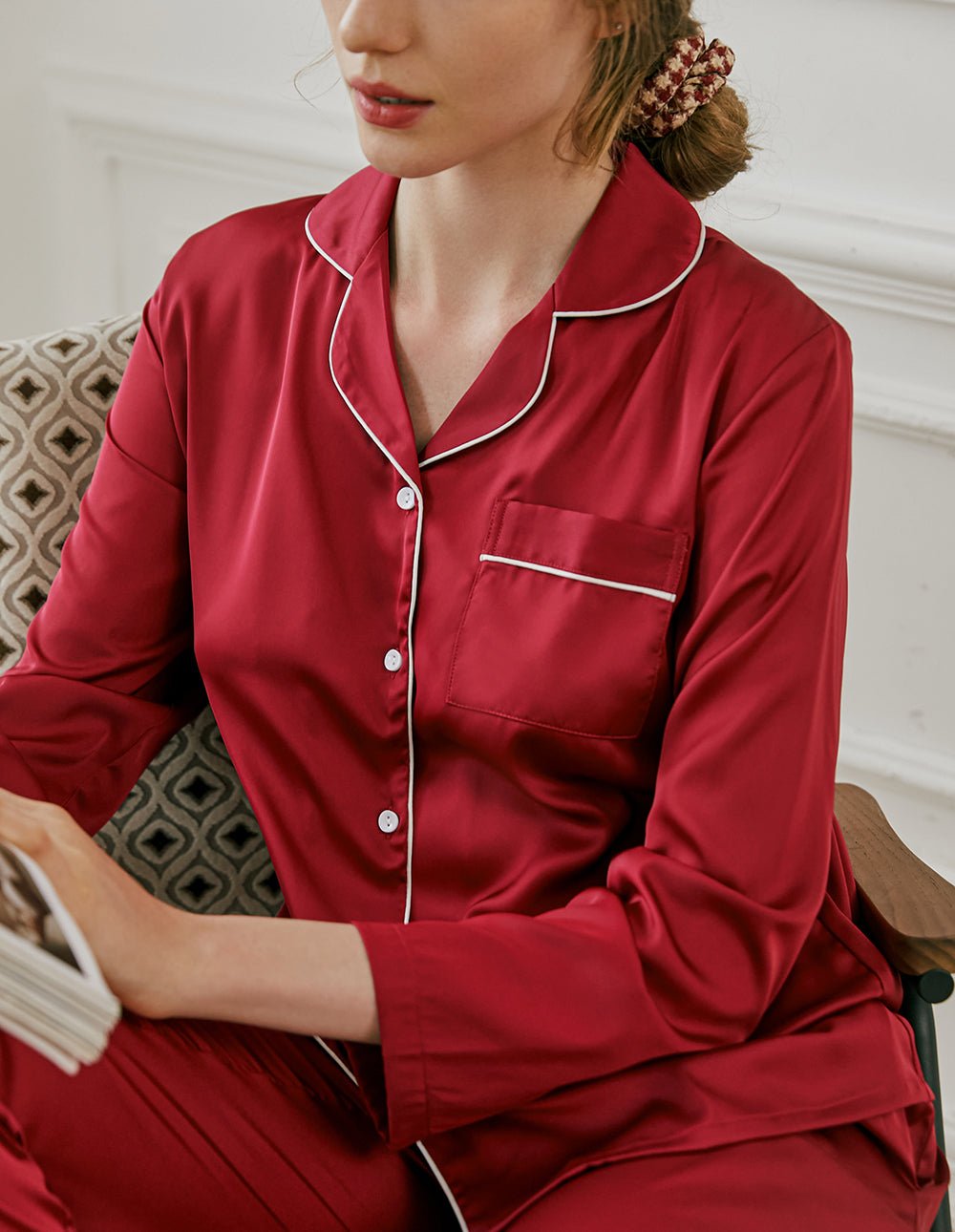 Close-up of wine red satin pajama top; contrast collar trim and chest pocket