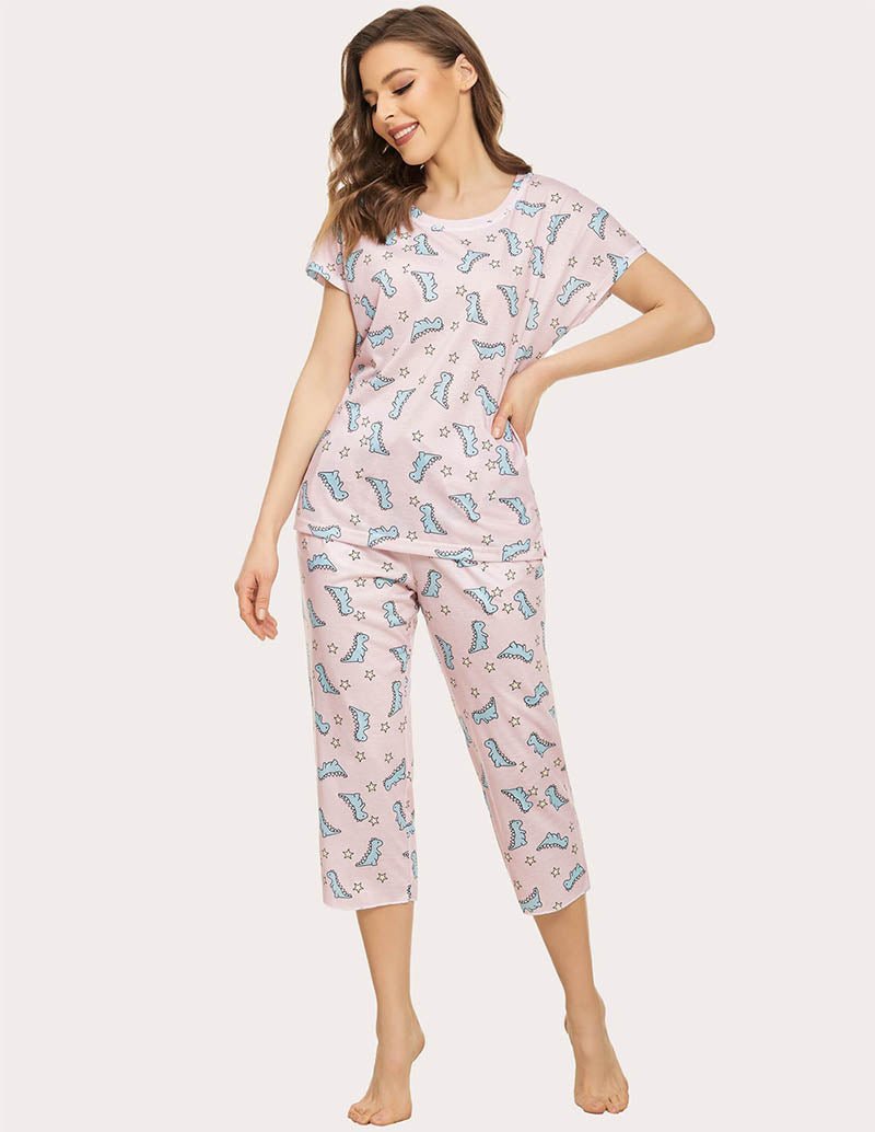 Women’s cropped pajama set in light pink with blue dinosaur print, short sleeves and capris