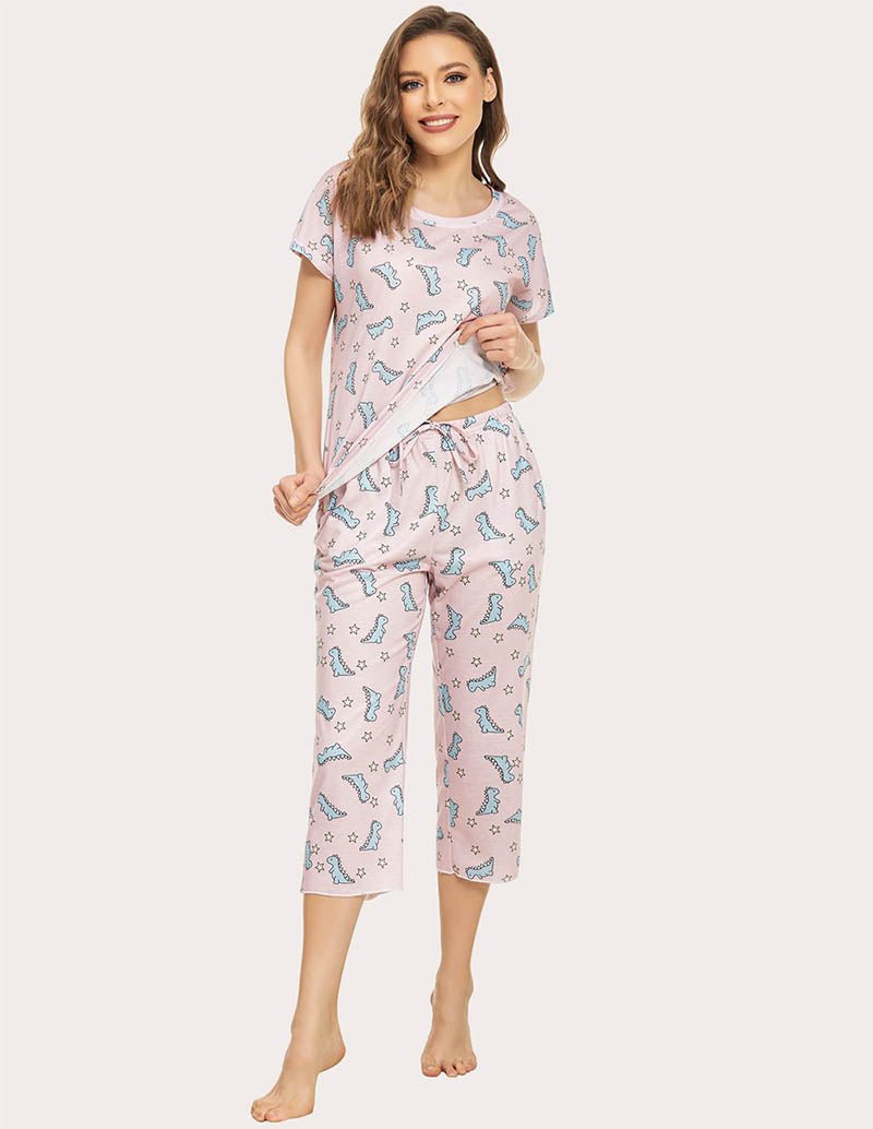 Women’s cropped pajama set in light pink with blue dinosaur print, relaxed fit capri pants