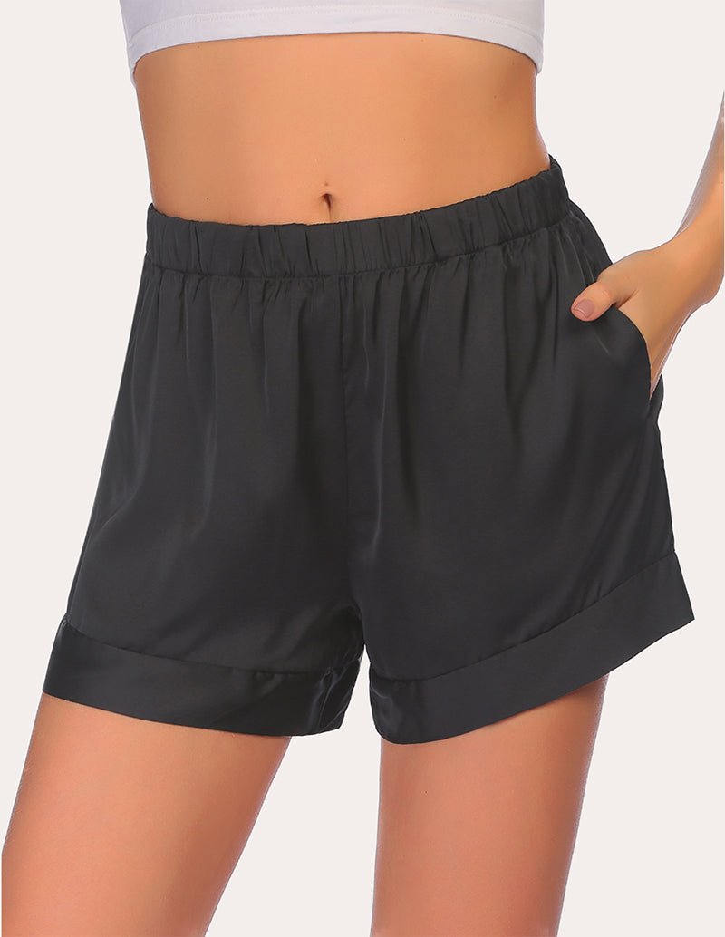 Black pajama shorts with elastic waist and relaxed fit, side profile