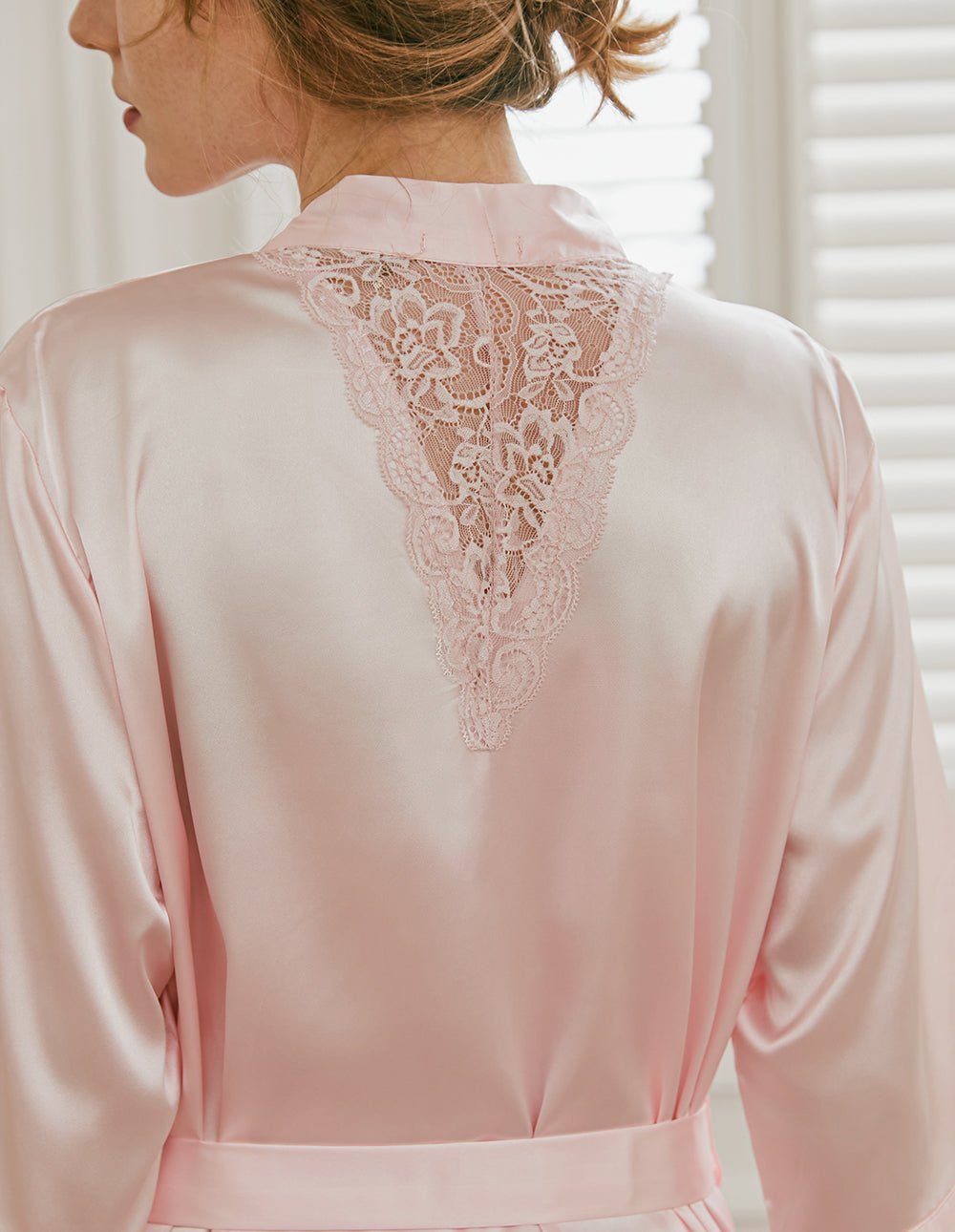 Back view of light pink satin robe with lace yoke and waist tie belt