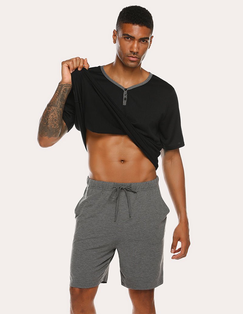 Men's black pajama top with V-neck and gray drawstring shorts, side pull-up pose