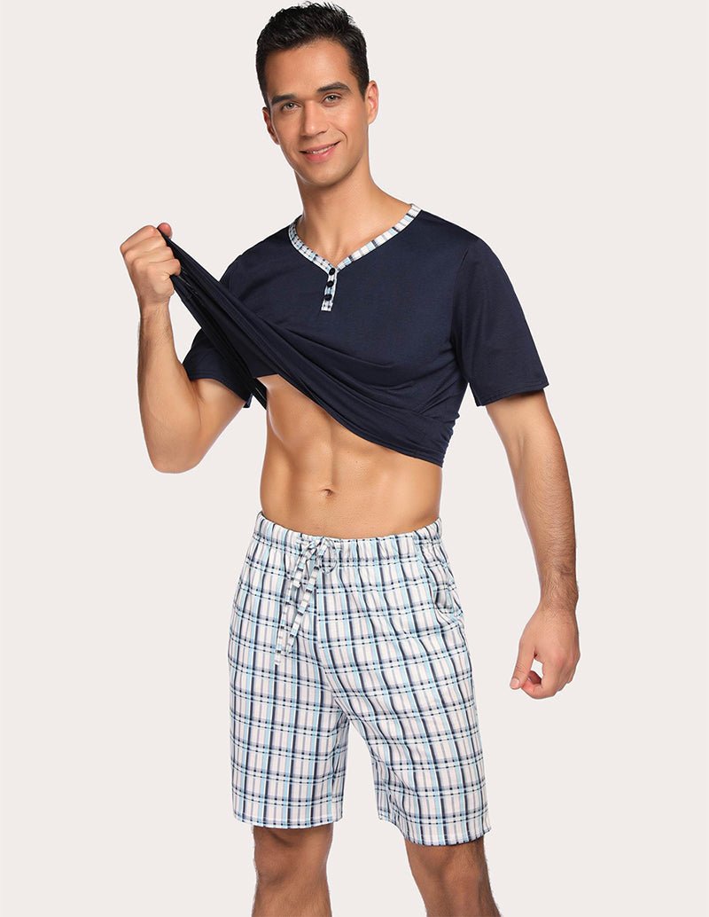Men's navy pajama henley top with blue plaid drawstring sleep shorts, front pose