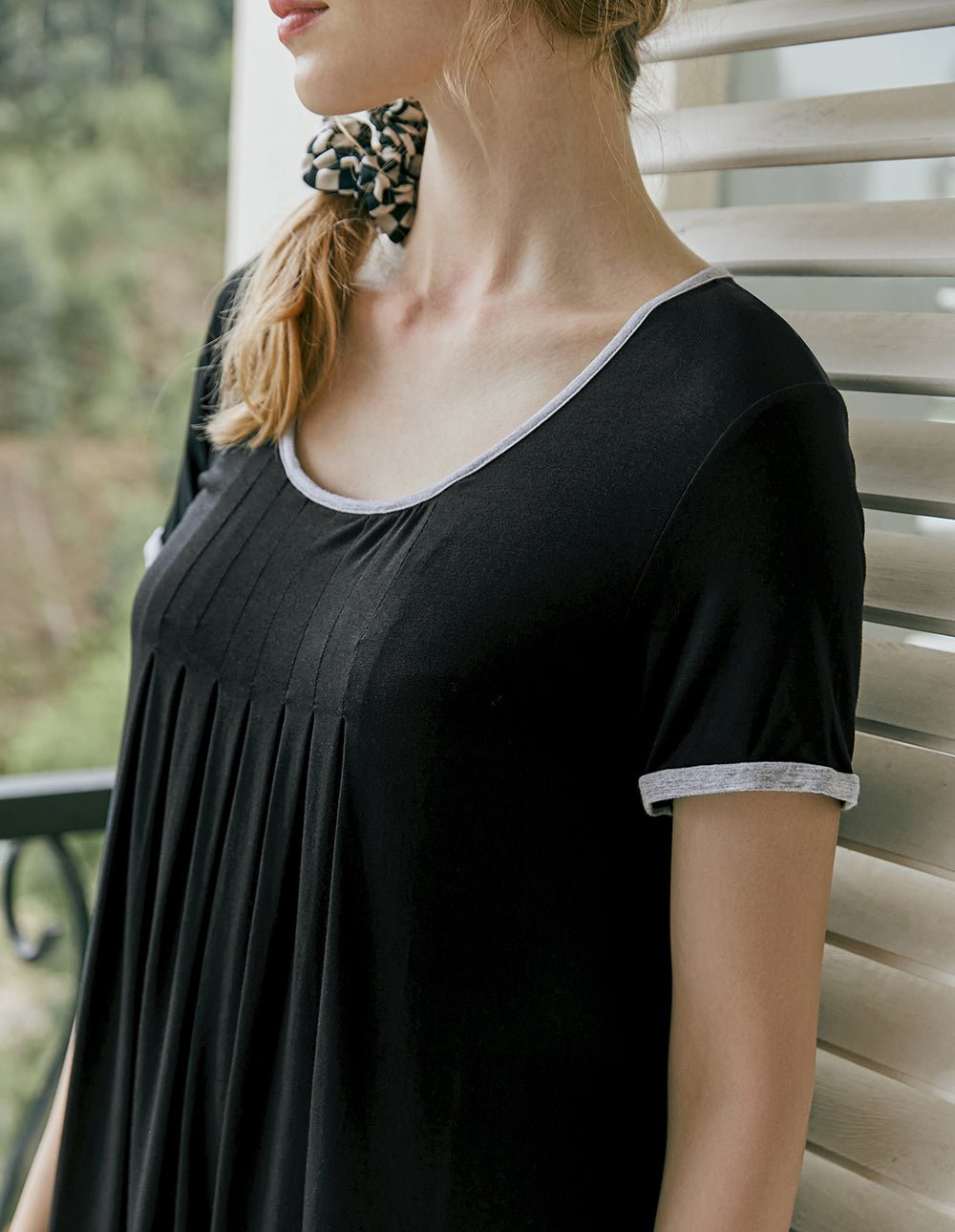 Close-up of dark pleated nightdress neckline and short sleeve with contrast trim