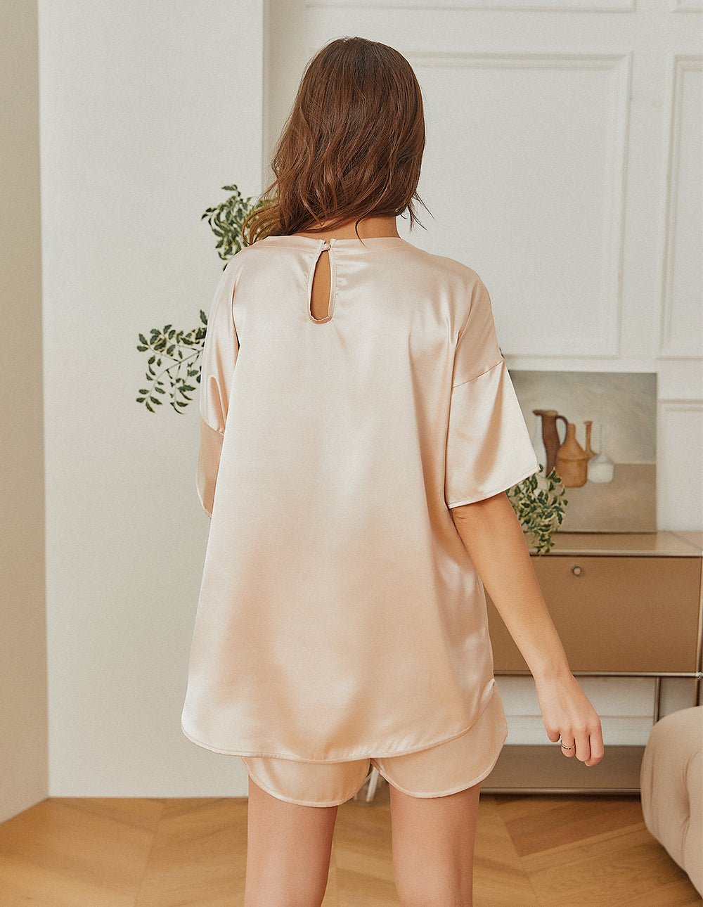 Champagne satin pajama set, back view: keyhole cutout on top with matching shorts