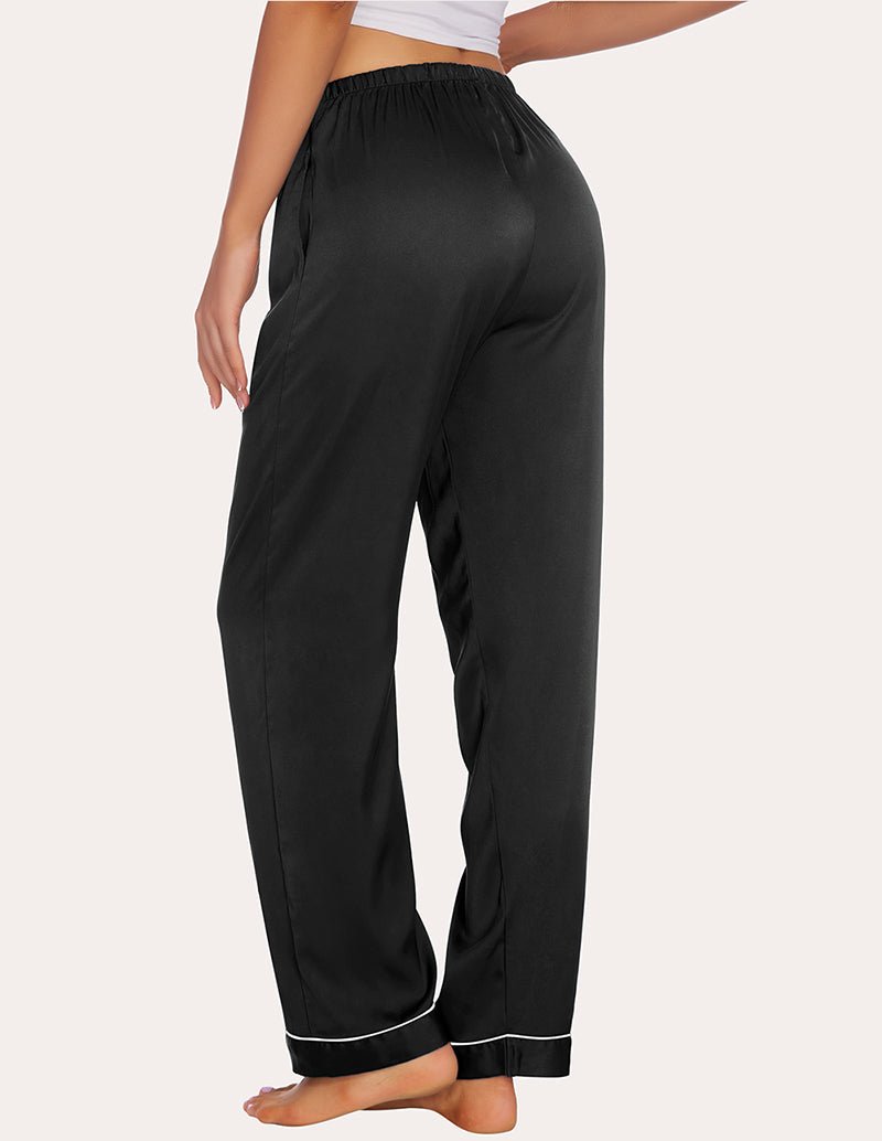 Black satin pajama pants with elastic waist and relaxed straight legs, contrast cuff piping