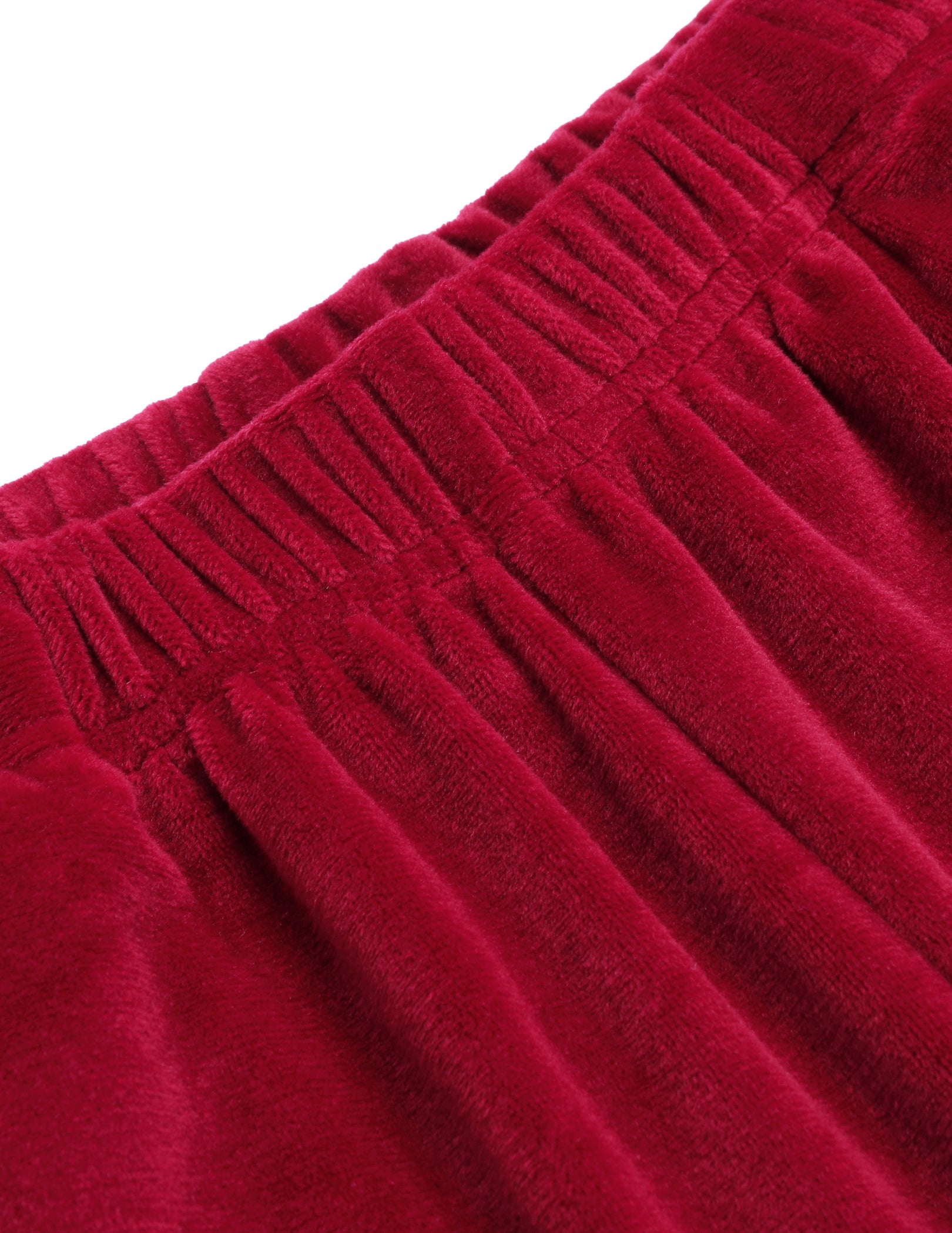 Red velour pajama waistband and pleats close-up, soft textured fabric