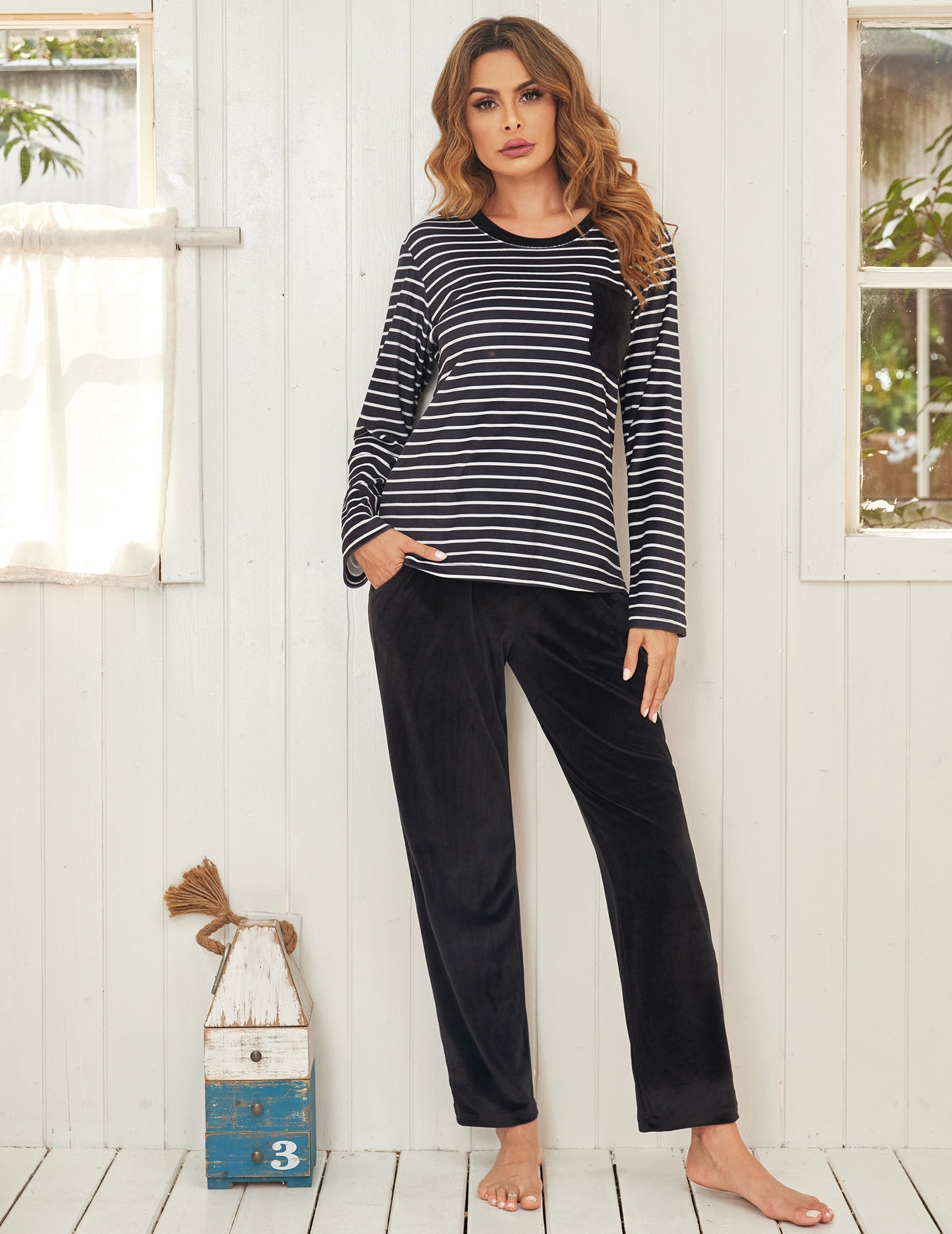 Velour pajama set with black-and-white striped long-sleeve top and dark long pants