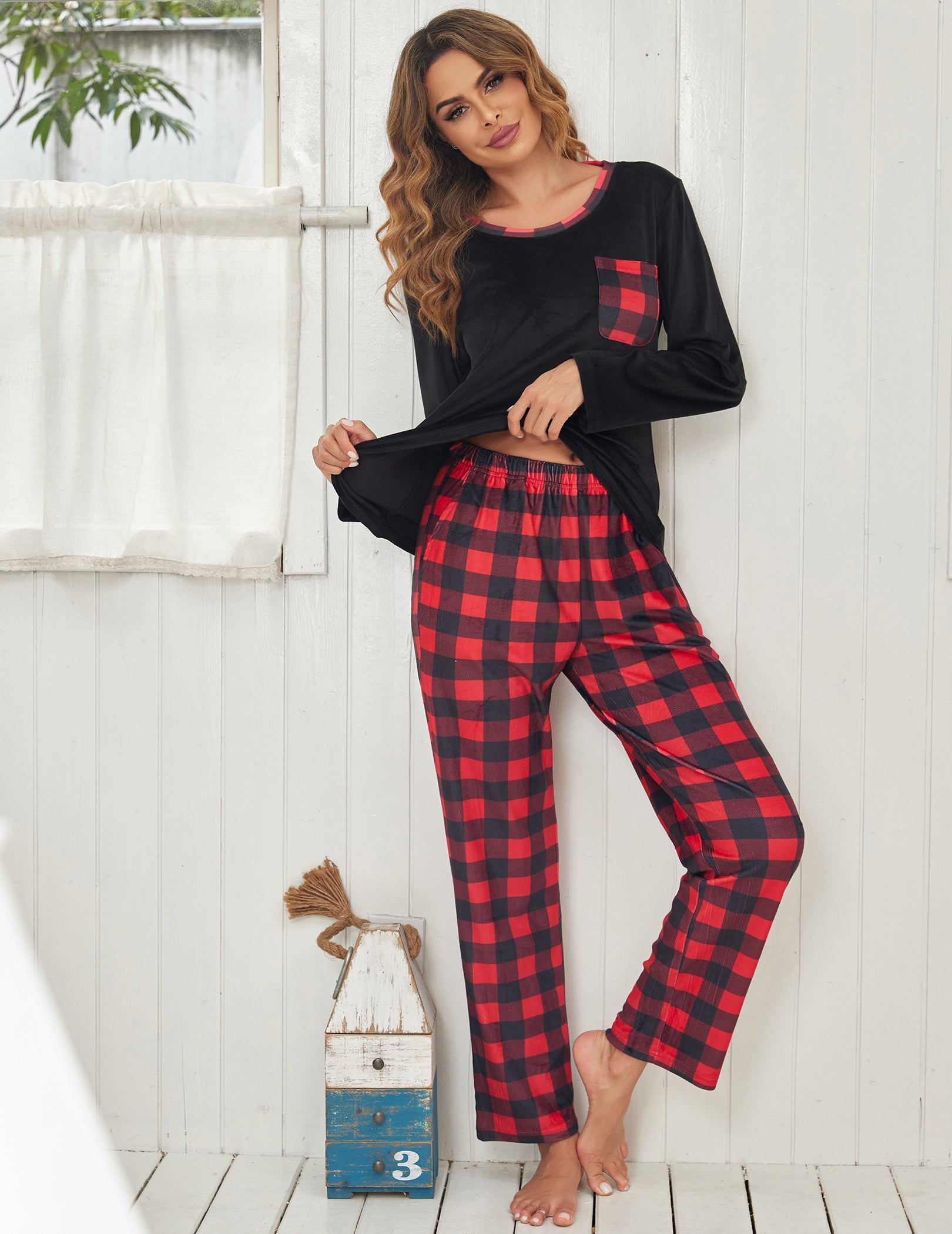 Black velour pajama set with red plaid pants, long sleeves and chest pocket detail