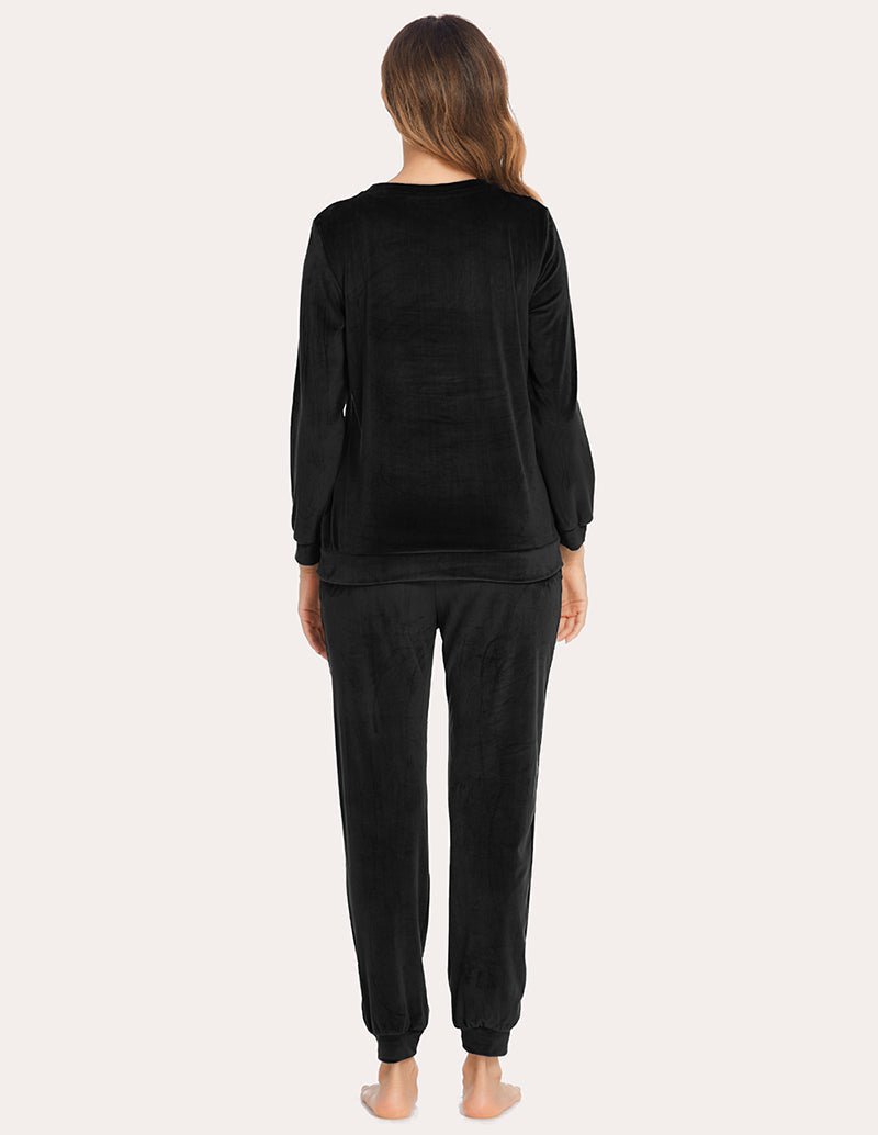 Back view: velour tracksuit set in black, long-sleeve top and matching jogger pants