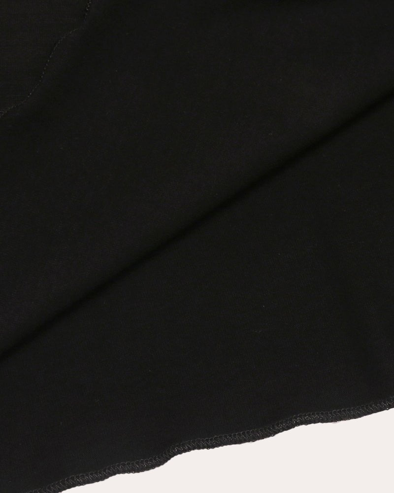 Schrägdetail: schwarzer Stoff mit sichtbarer Naht am Saum des Nachthemds