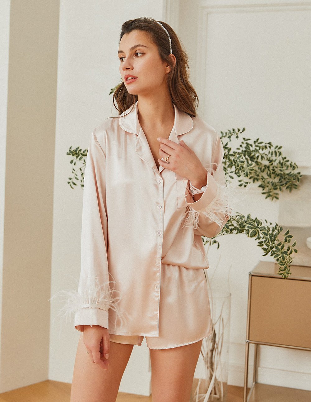 Champagne satin pajama set with button-up shirt and feather-trim sleeves, matching shorts